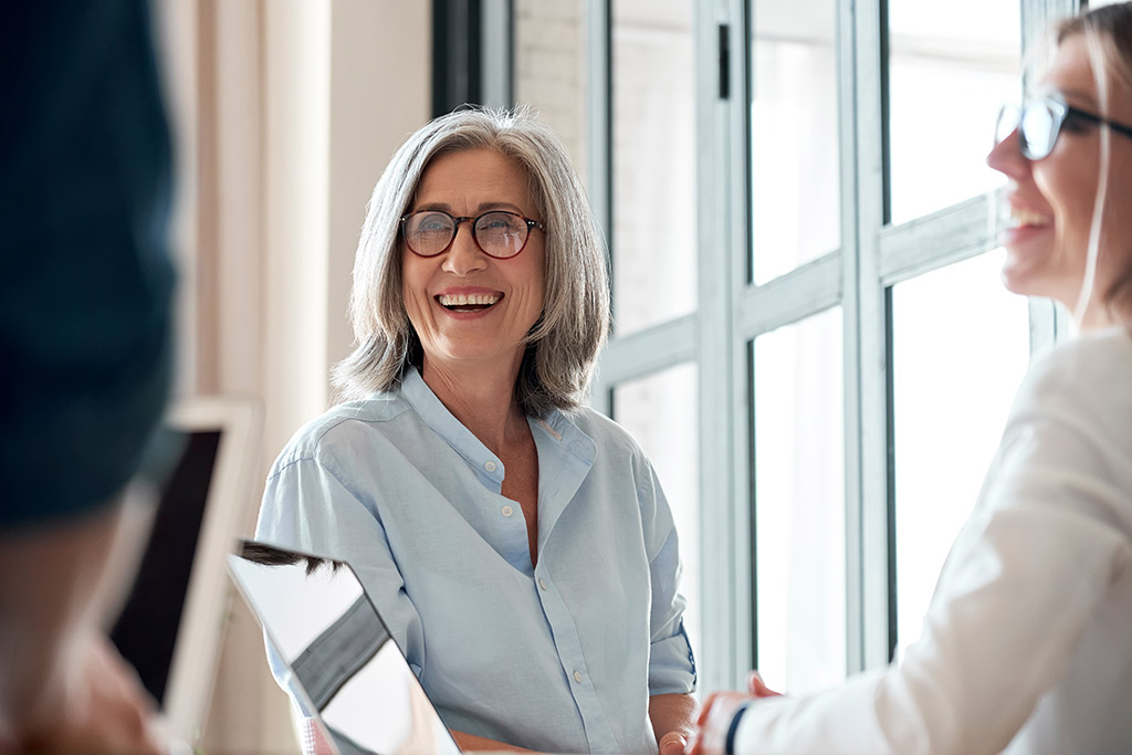 Happy mature old female mentor coach tablet