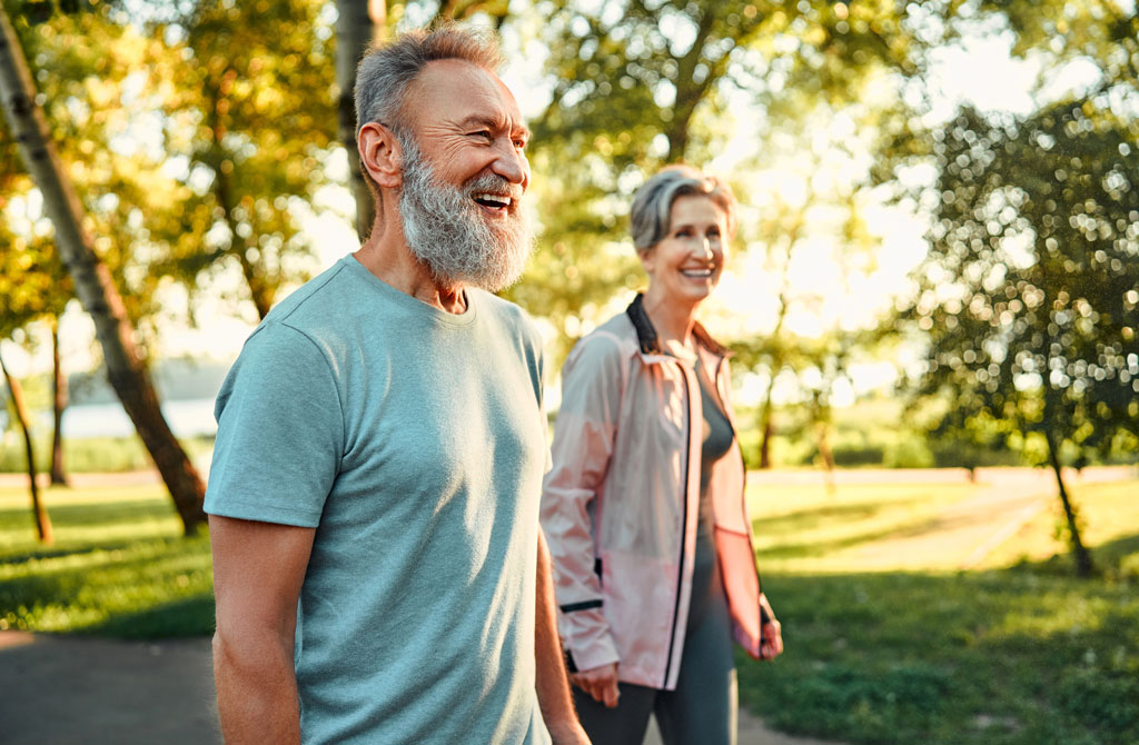 Healthy elderly couple walking tablet
